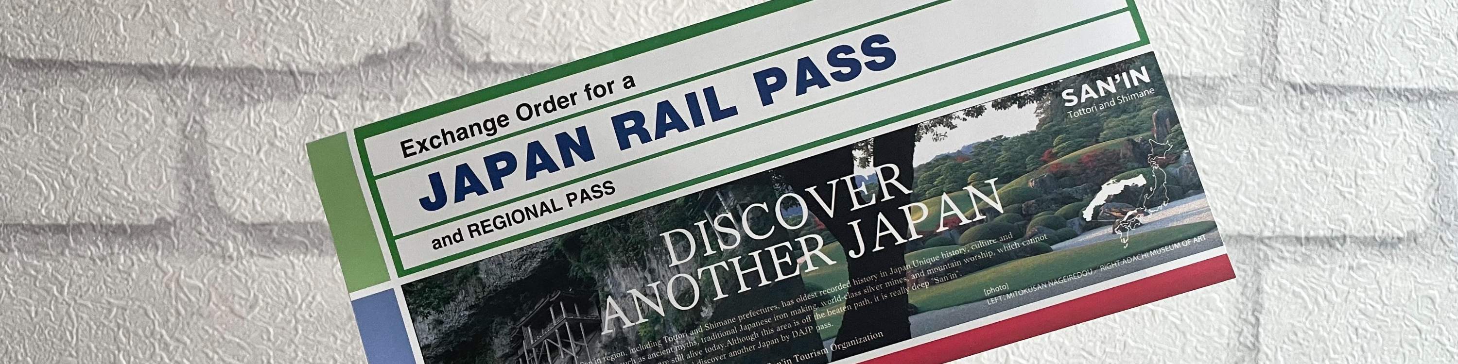 a hand holding up an exchange order for the Japan Rail Pass