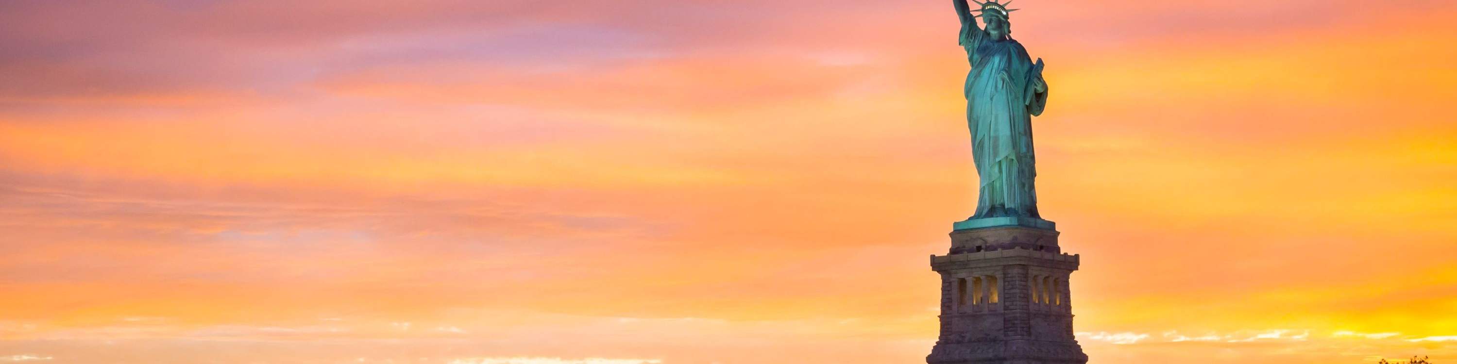 Golden sunset over New York Harbor with the Statue of Liberty in view