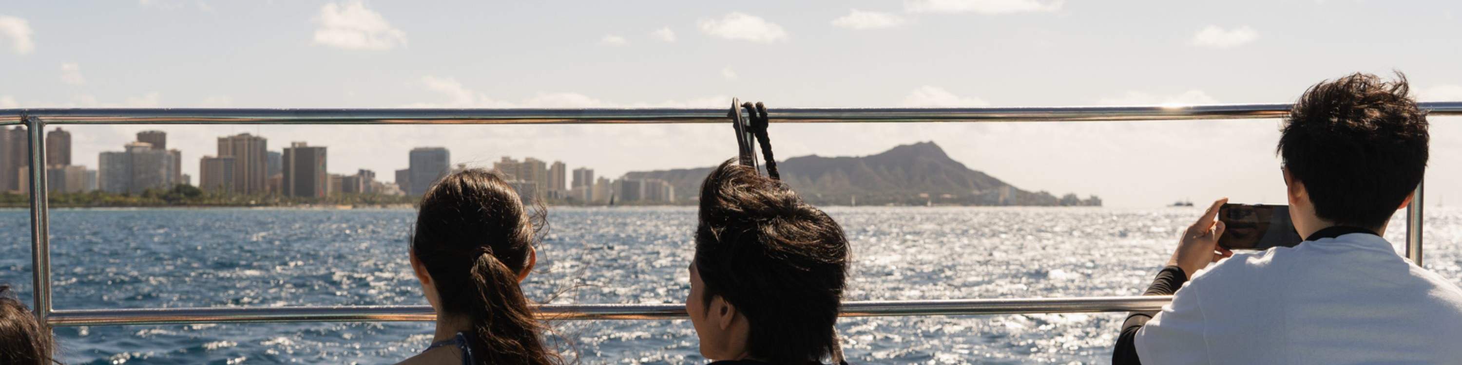 Pasajeros sentados en la cubierta, disfrutando de la brisa del mar y las vistas panorámicas