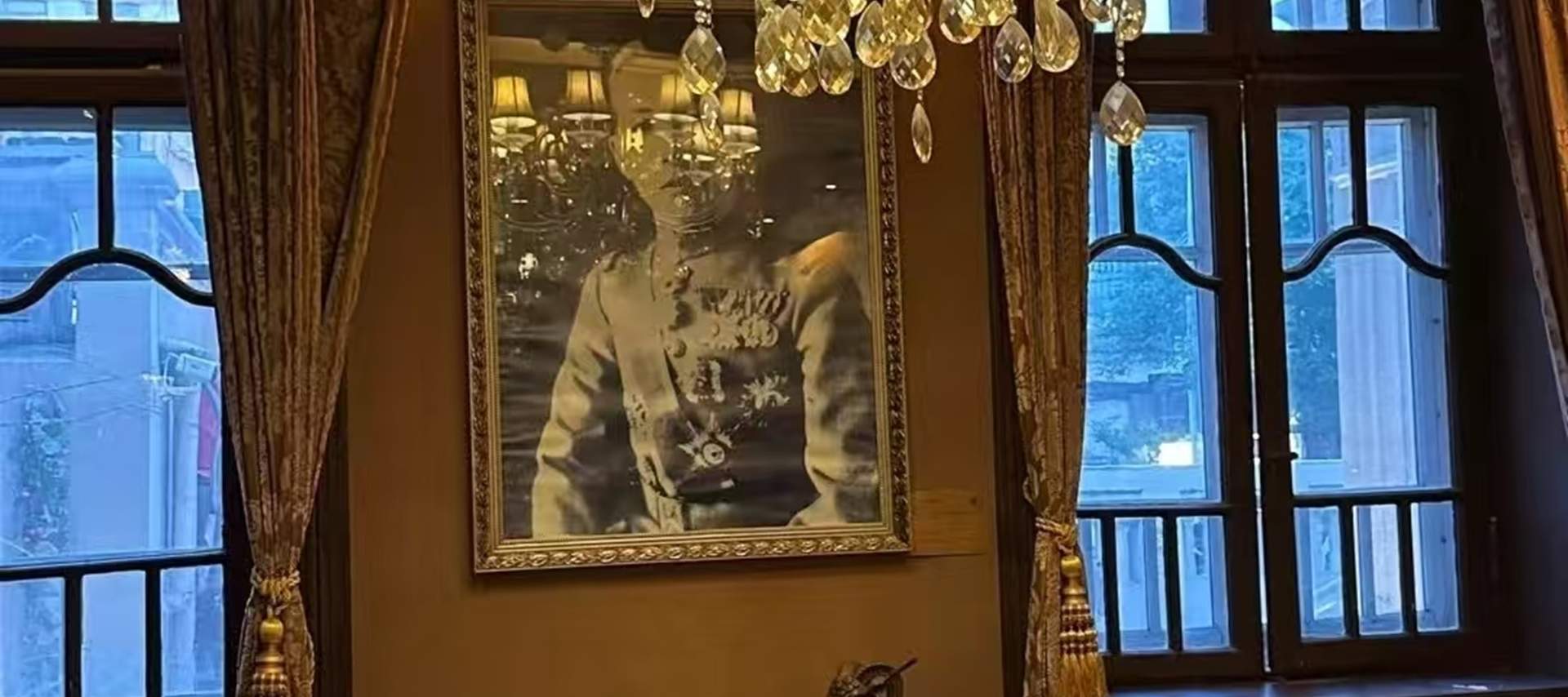 The living room is decorated with European-style genuine leather sofas, redwood coffee tables, and floor lamps from the period of the Republic of China. Western-style oil paintings hang on the walls, and a crystal chandelier hangs from the ceiling, reveal