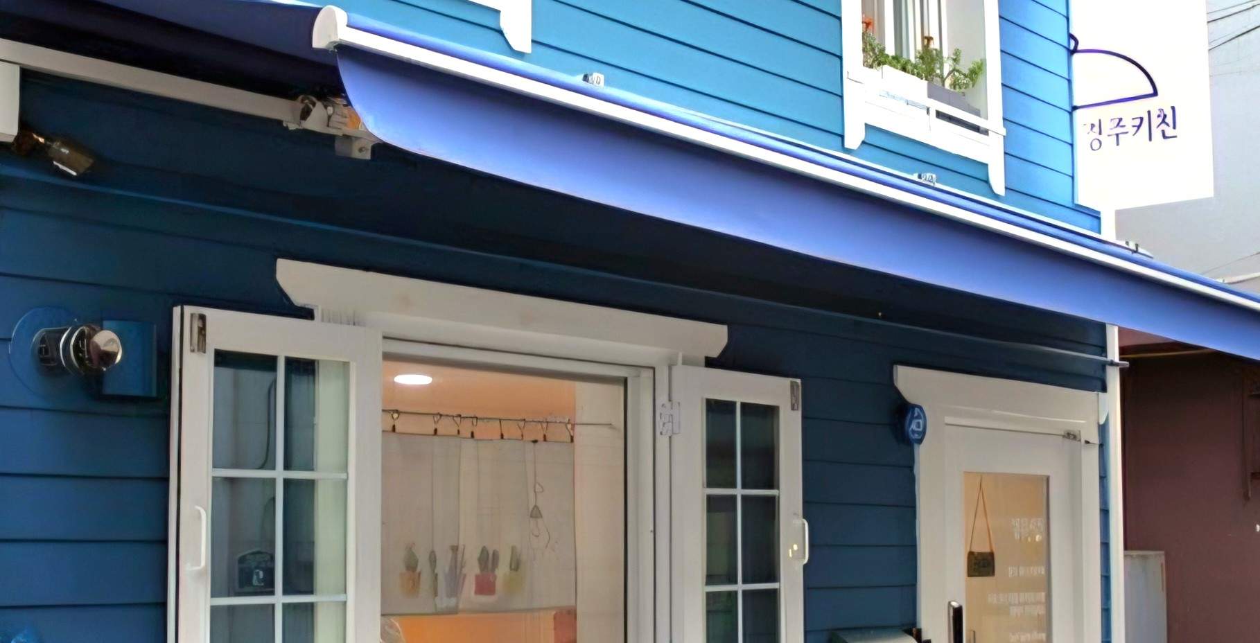 庆州厨房标志性的蓝色房屋——一个明亮、温馨的场所，提供有趣的紫菜包饭烹饪体验课程。