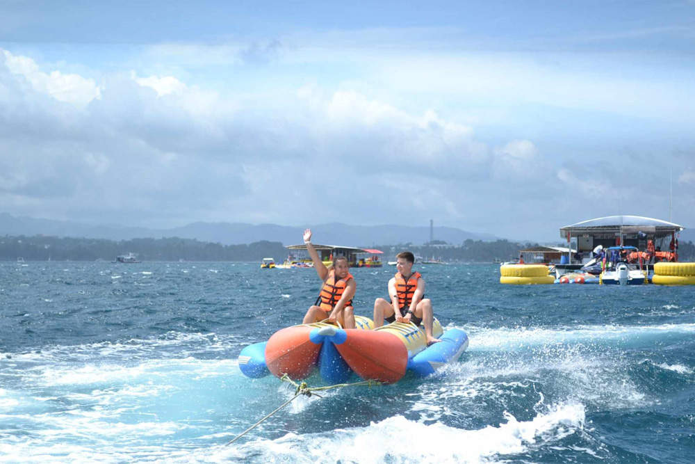 Pasangan di atas banana boat yang ditarik melintasi lautan