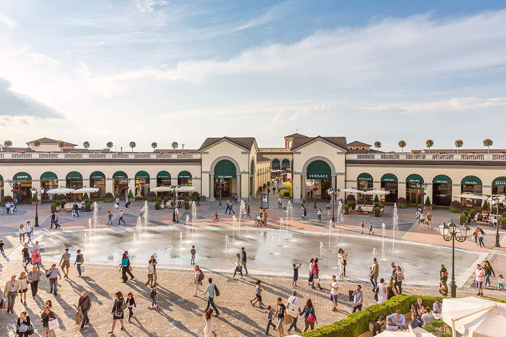 turisti e residenti che passeggiano nel centro commerciale in stile villaggio