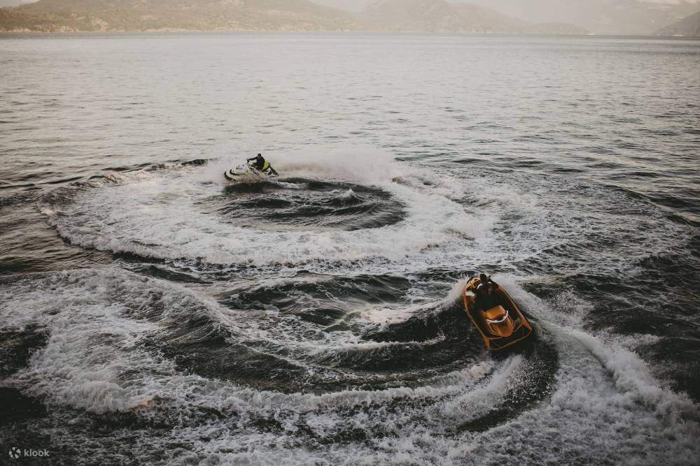 Một người lướt ván rẽ sóng, tạo nên một màn nước ngoạn mục phía sau