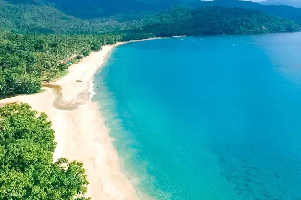 Pulau yang dikelilingi oleh perairan berwarna biru kehijauan
