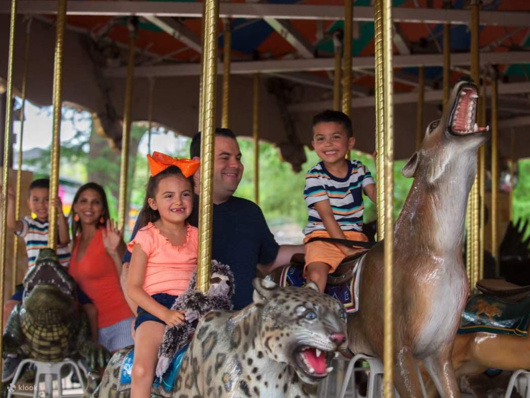 A family laughs together while riding their wild creature of choice on the animal carousel