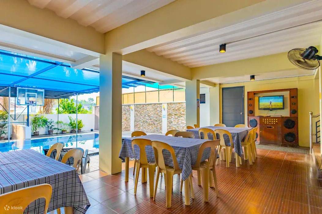 Coin repas extérieur avec tables et chaises au bord d'une piscine