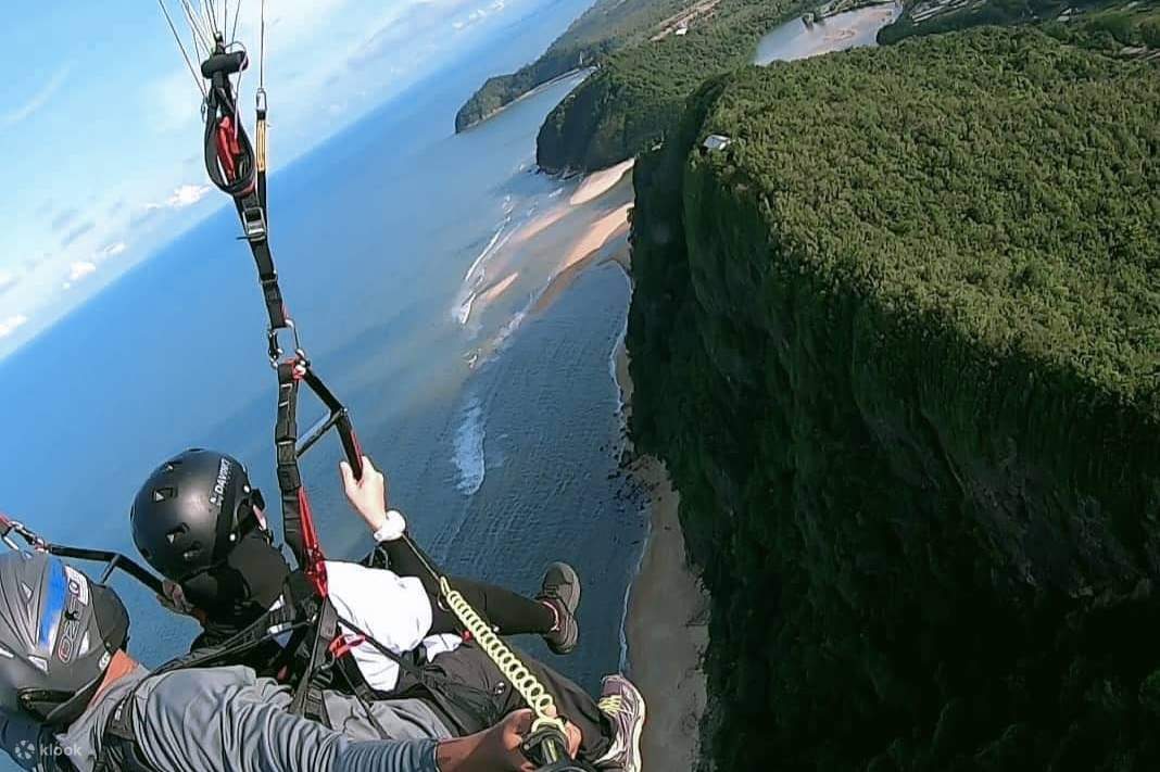 Parapente sobre el océano con vistas a la montaña