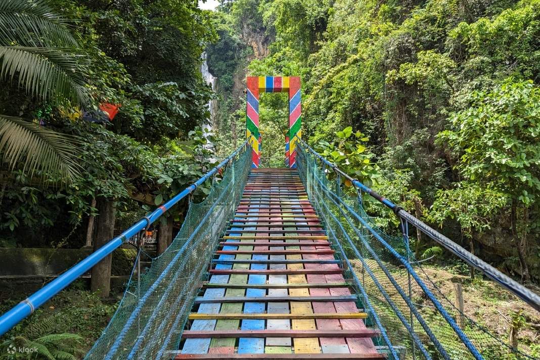 Se llega a la cascada Mantayupan a través de un puente colorido.