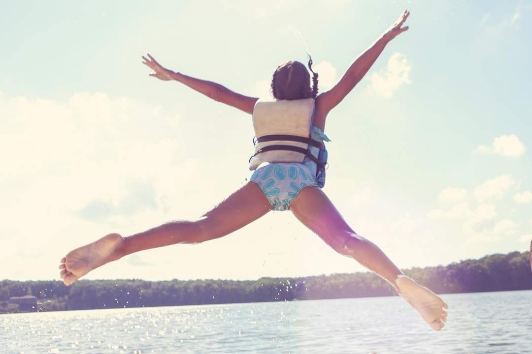 L'enfant saute dans l'eau.