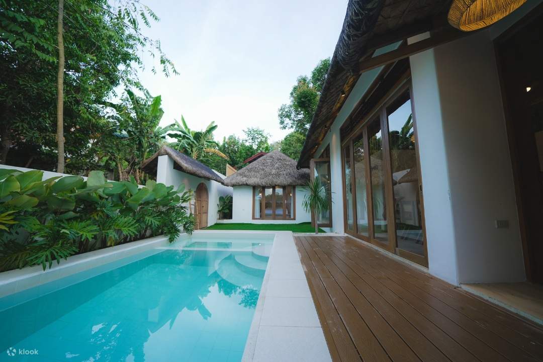 茅草屋頂的迷人房屋前有一個漂亮的游泳池