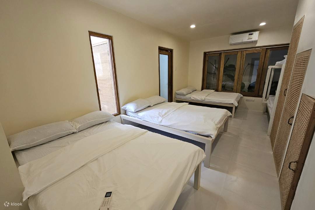 kamar nyaman dengan tiga tempat tidur dan jendela yang menghadap ke pemandangan indah