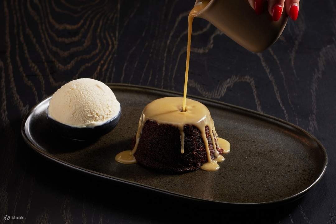 สัมผัสประสบการณ์พุดดิ้งอินทผาลัมเหนียวหนึบ ซึ่งเป็นส่วนหนึ่งของ**ประสบการณ์**อาหาร 3 คอร์สสุดพิเศษ ราดด้วยบัตเตอร์สกอตช์และไอศกรีม