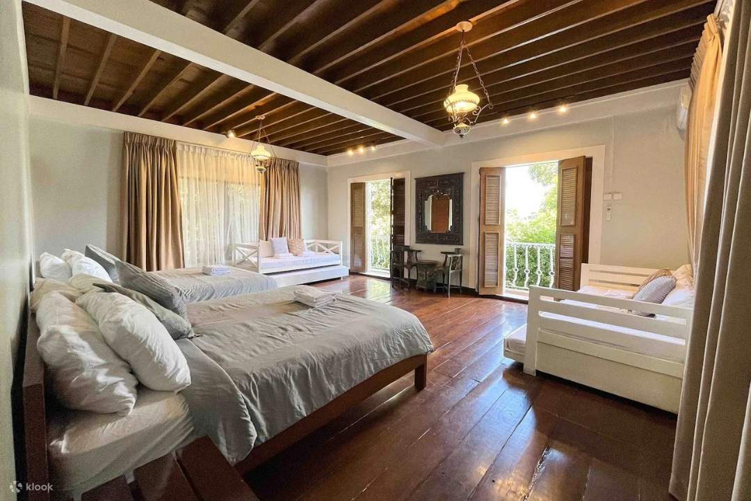 Chambre principale avec vue sur la nature, comprenant deux lits et deux canapés