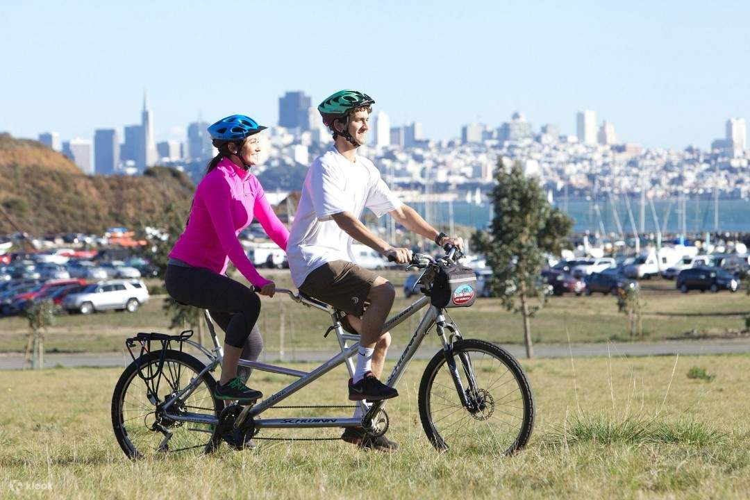 hai người đạp xe ở đâu đó trên đồng cỏ