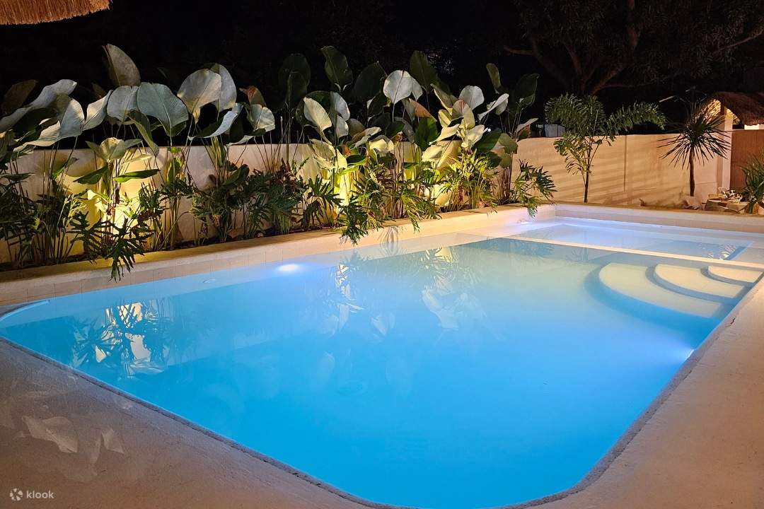 una scintillante piscina di notte, illuminata da luci vivaci, che crea un'atmosfera incantevole