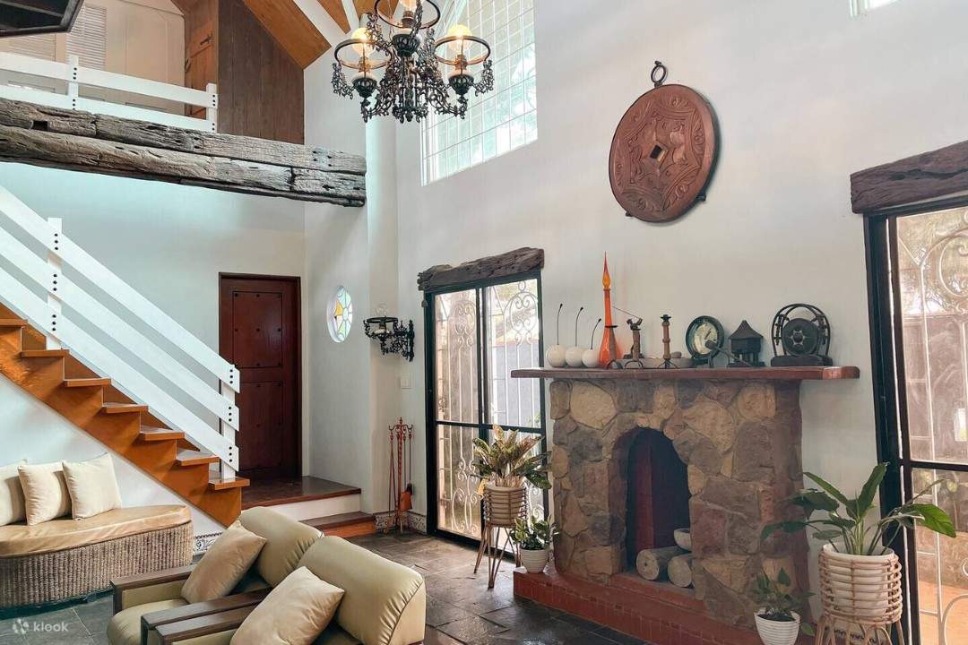 Un salon chaleureux avec une cheminée et un escalier, idéal pour se détendre et passer du temps avec ses proches