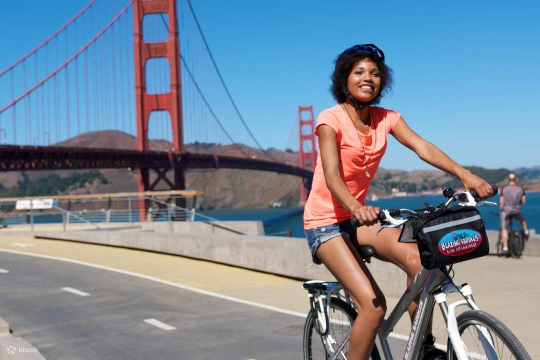 una donna che pedala vicino al Golden Gate Bridge
