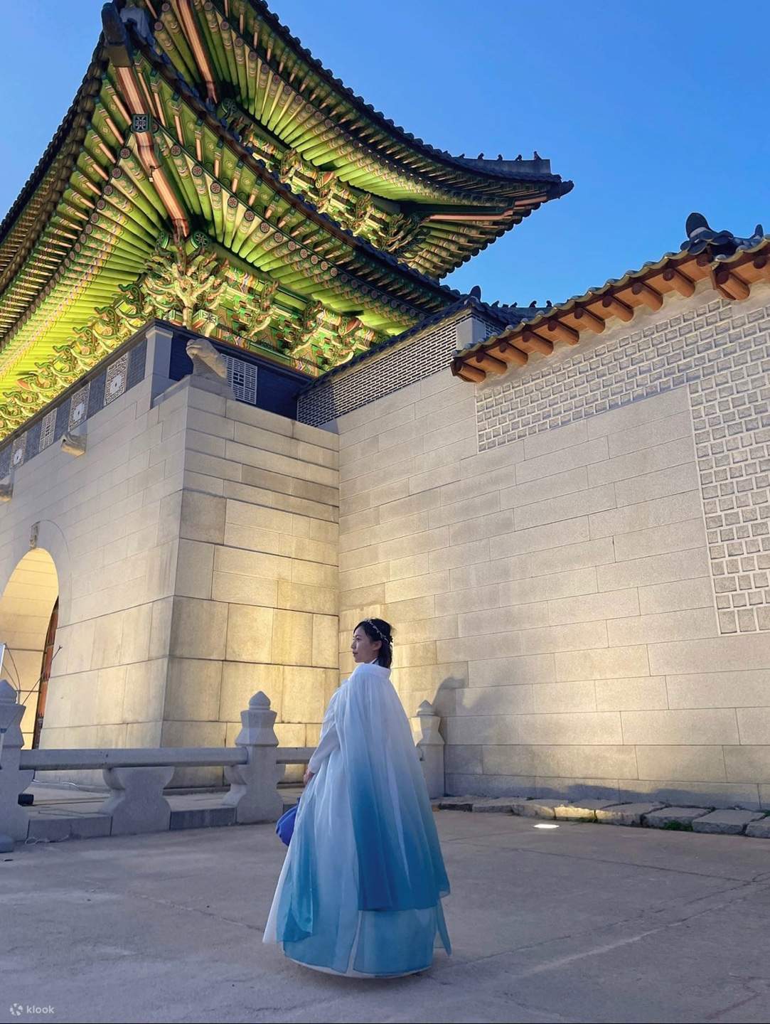 seorang gadis memakai hanbok di hadapan Gwanghwamun