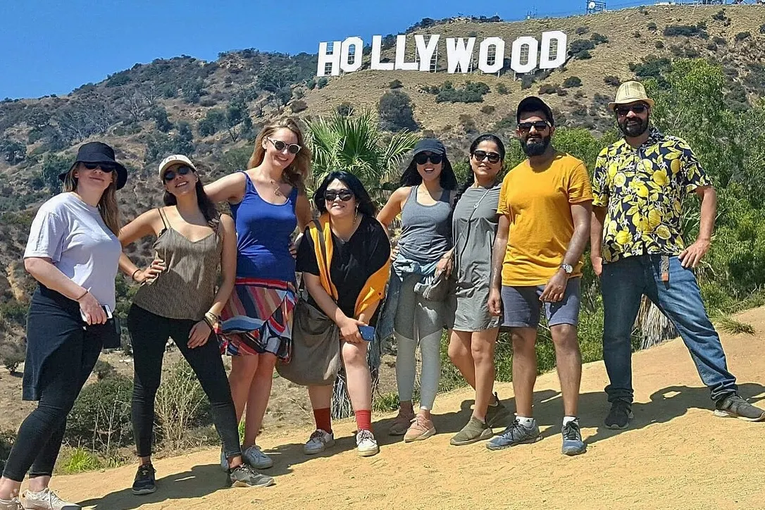 People standing in front of the Hollywood sign