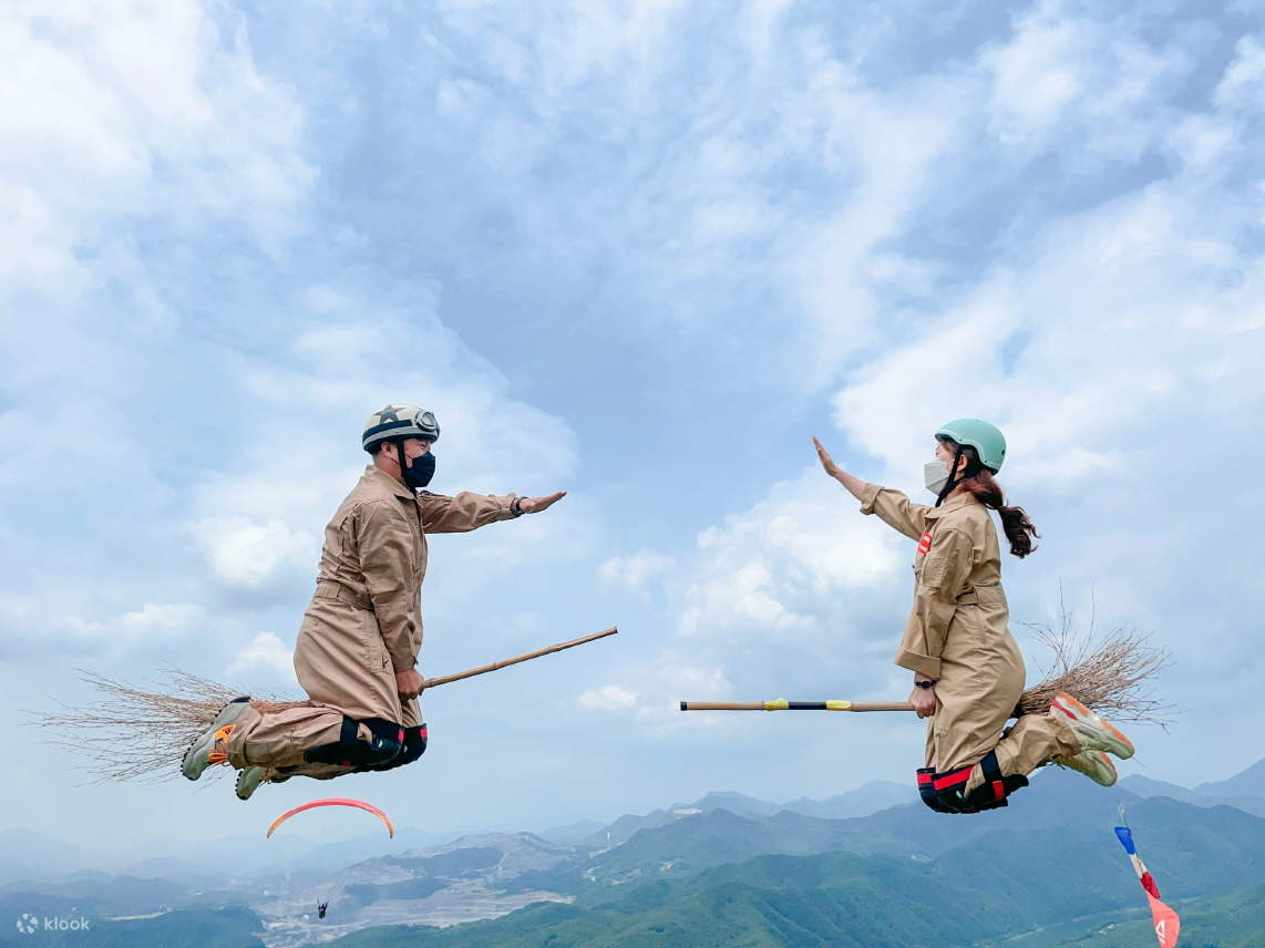 Two people are riding a broom