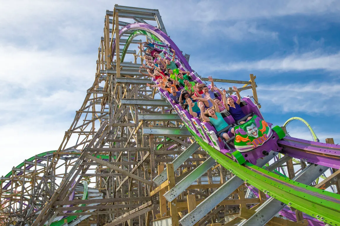 People with their hands up in a roller coaster