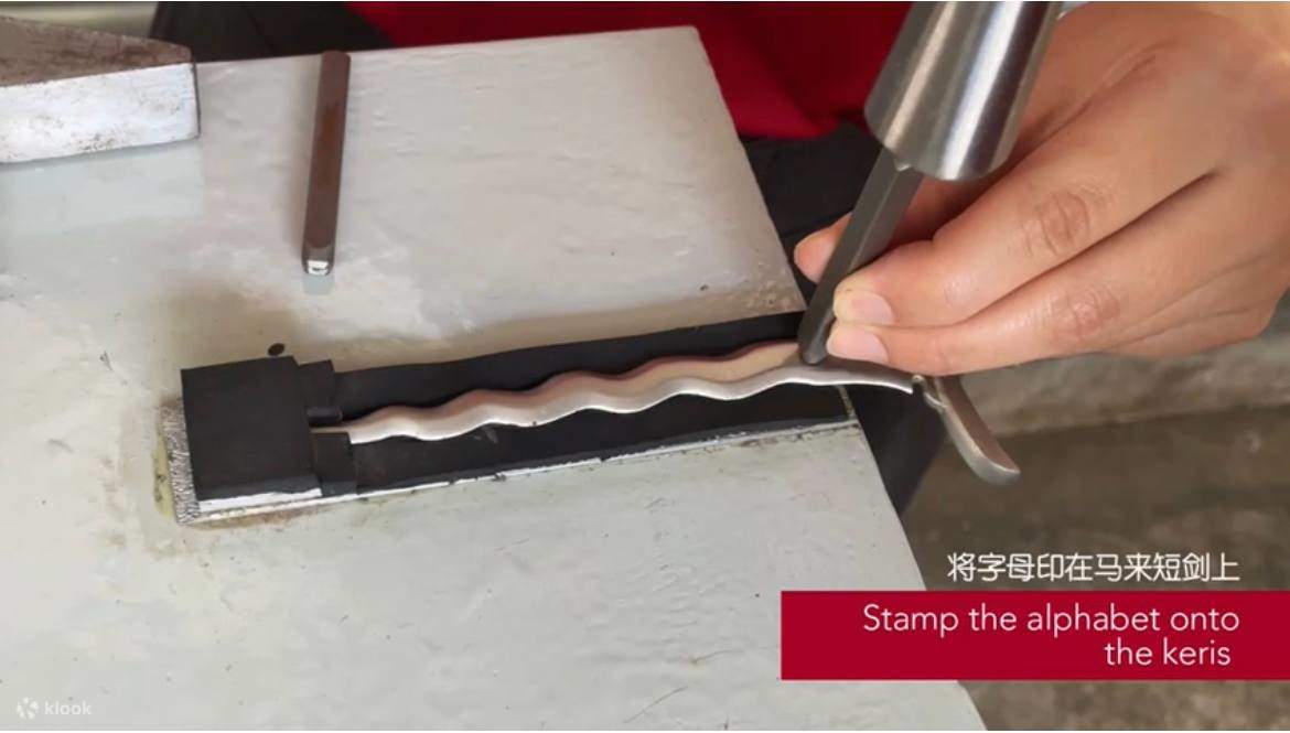 用小锤子敲击马来剑上的字母模具