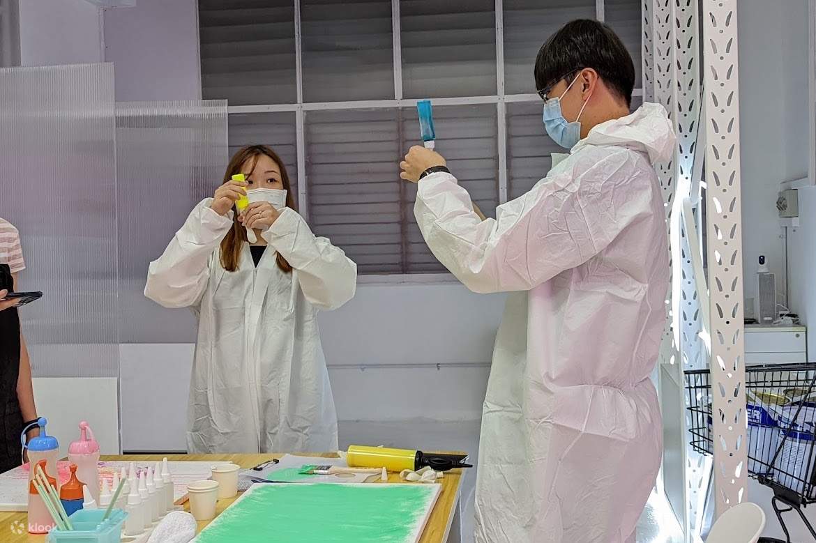 a couple filling in paint in balloon