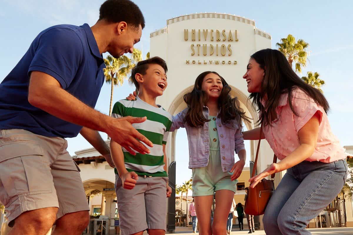 Beams with happiness for a photo in front of the grand Universal Studios globe