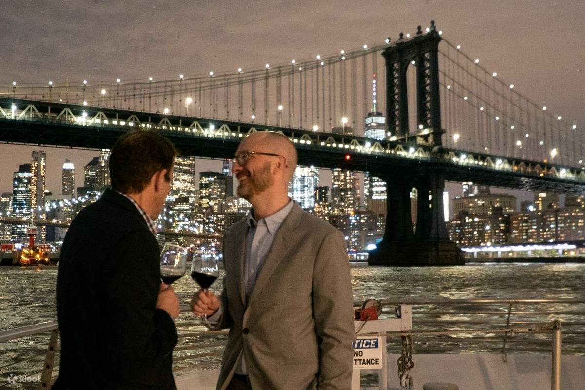 Huéspedes disfrutando de bebidas y de una vista nocturna de Nueva York