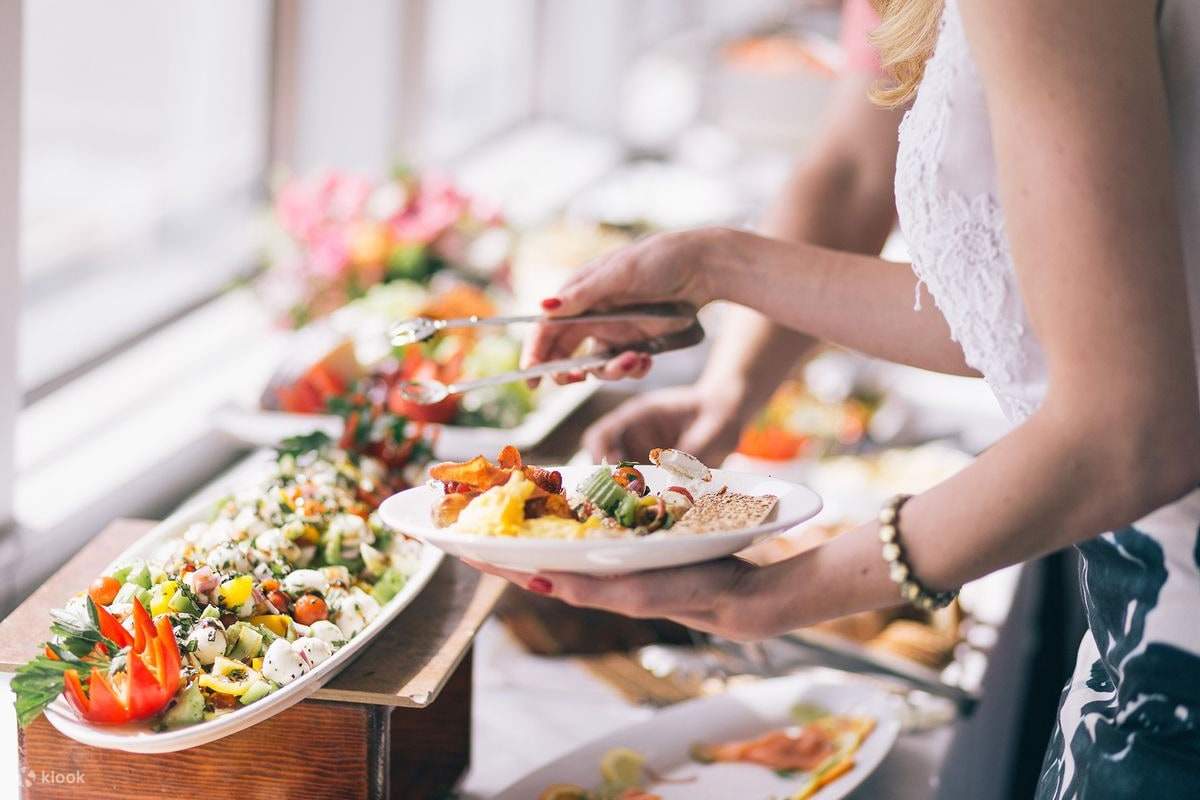 ผู้หญิงกำลังรับอาหารจากบุฟเฟ่ต์