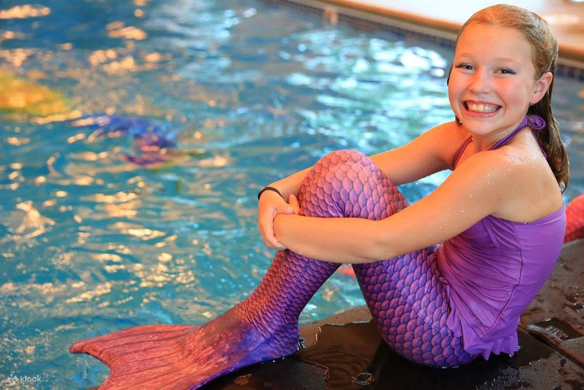 Một bé gái mặc trang phục nàng tiên cá màu tím