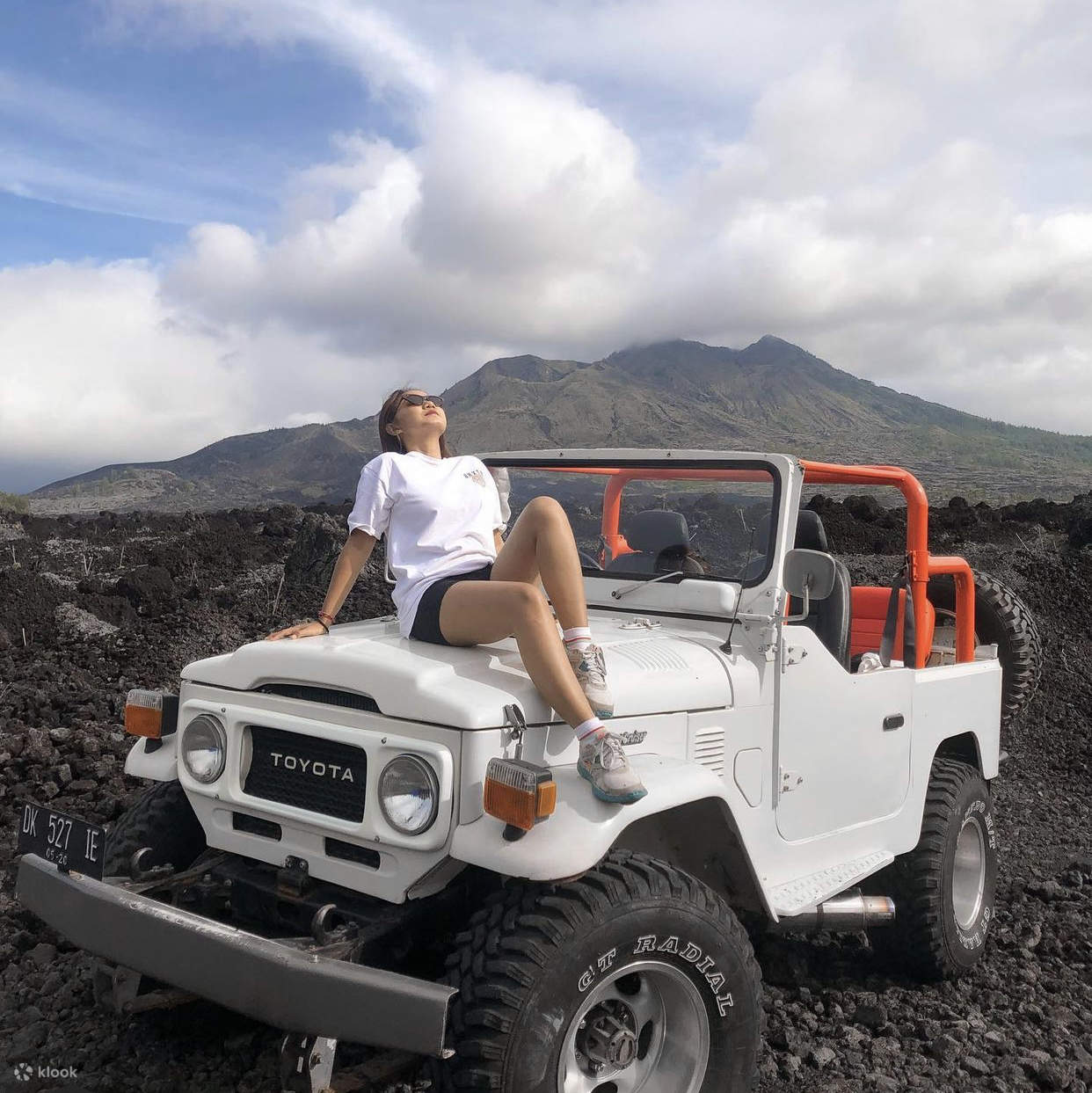 seorang pria duduk di atas jeep