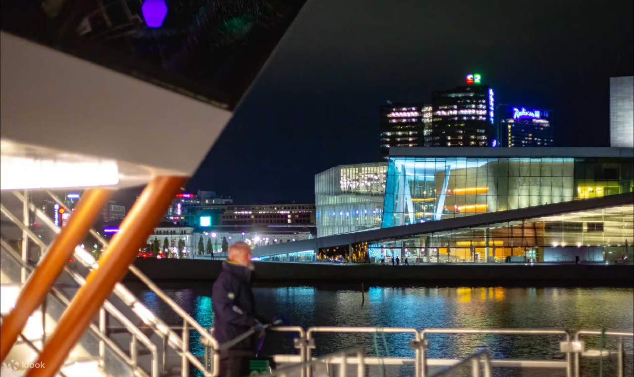 The cruise boat is beautifully lit with colorful lights, offering stunning nighttime views of Oslo city