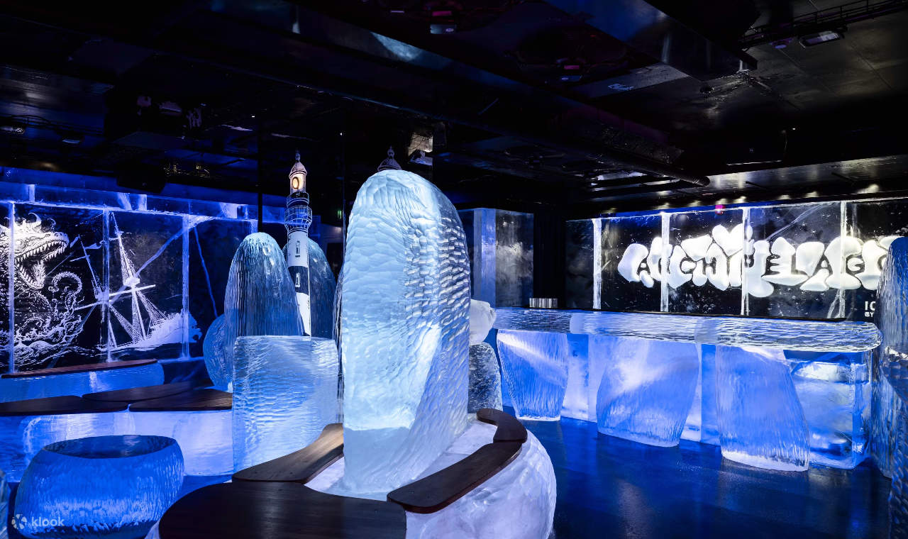 Des sculptures de glace détaillées forment des formes abstraites, magnifiquement illuminées à l'intérieur de la salle d'exposition glacée.