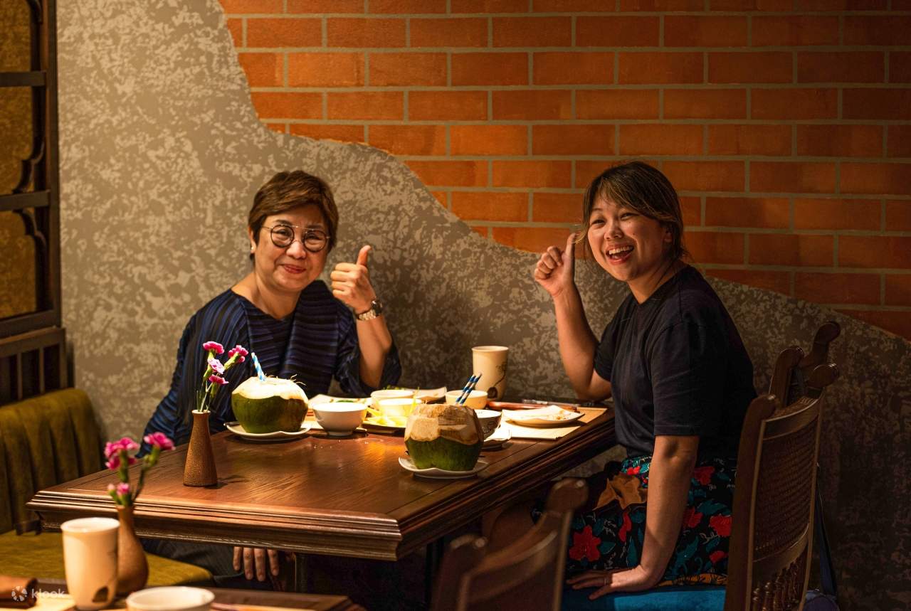 Hai người phụ nữ cùng nhau thưởng thức bữa ăn tại bàn, xung quanh là những món ăn ngon