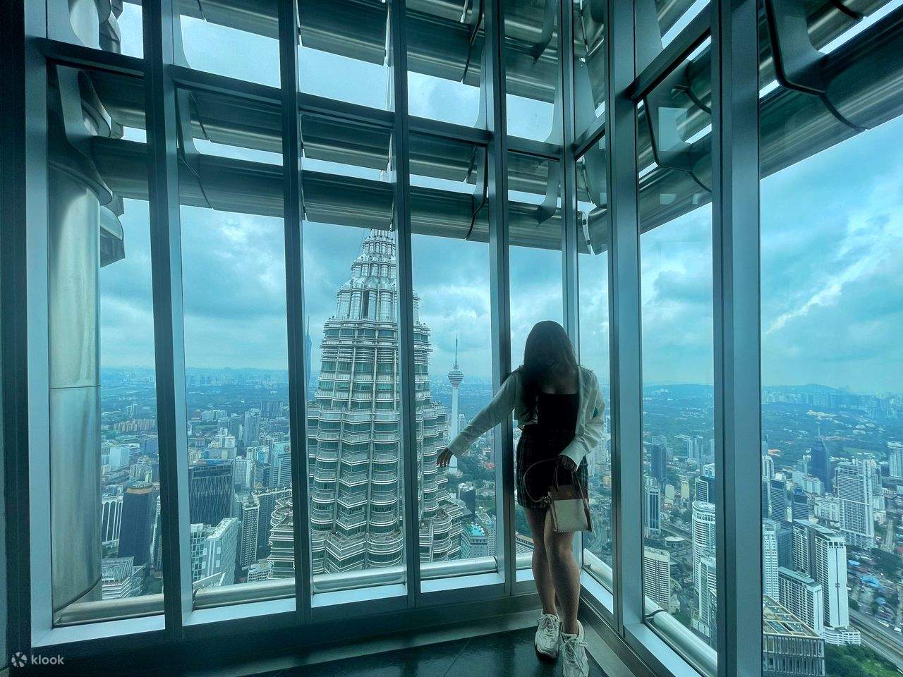 berfoto di petronas twin tower bersama orang lain