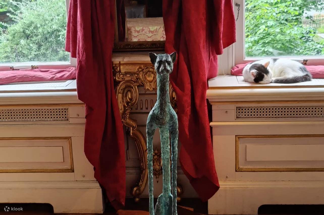 アムステルダムにある猫の彫刻。背景には眠っている猫がいます。