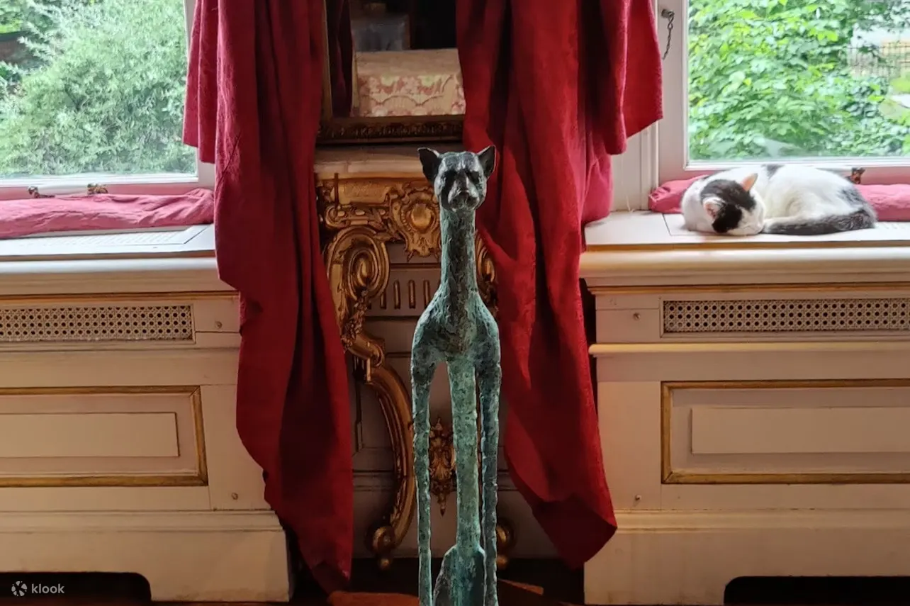 阿姆斯特丹的一座猫雕塑，一只猫在背景中睡觉