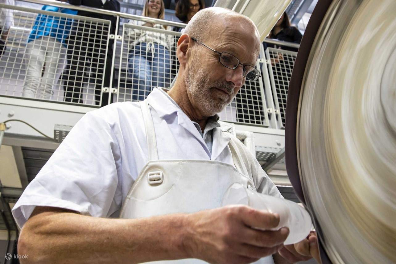 作業員が、ガラスを研磨して滑らかな仕上がりにする方法を実演しています