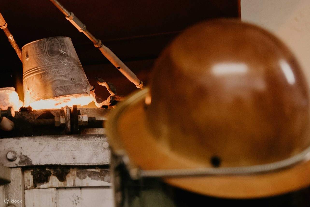 ผู้ชายคนหนึ่งกำลังเฝ้าดูลาวาที่ไหลออกมาจากถัง