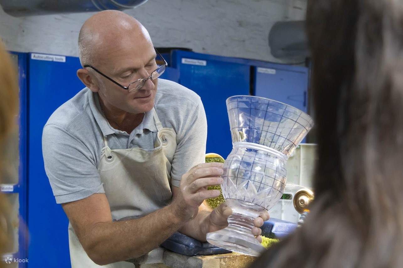 Работник Дома Waterford рассказывает о деталях стеклянной вазы.