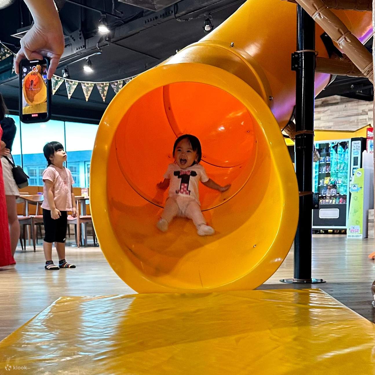 fille glissant sur un toboggan dans une aire de jeux