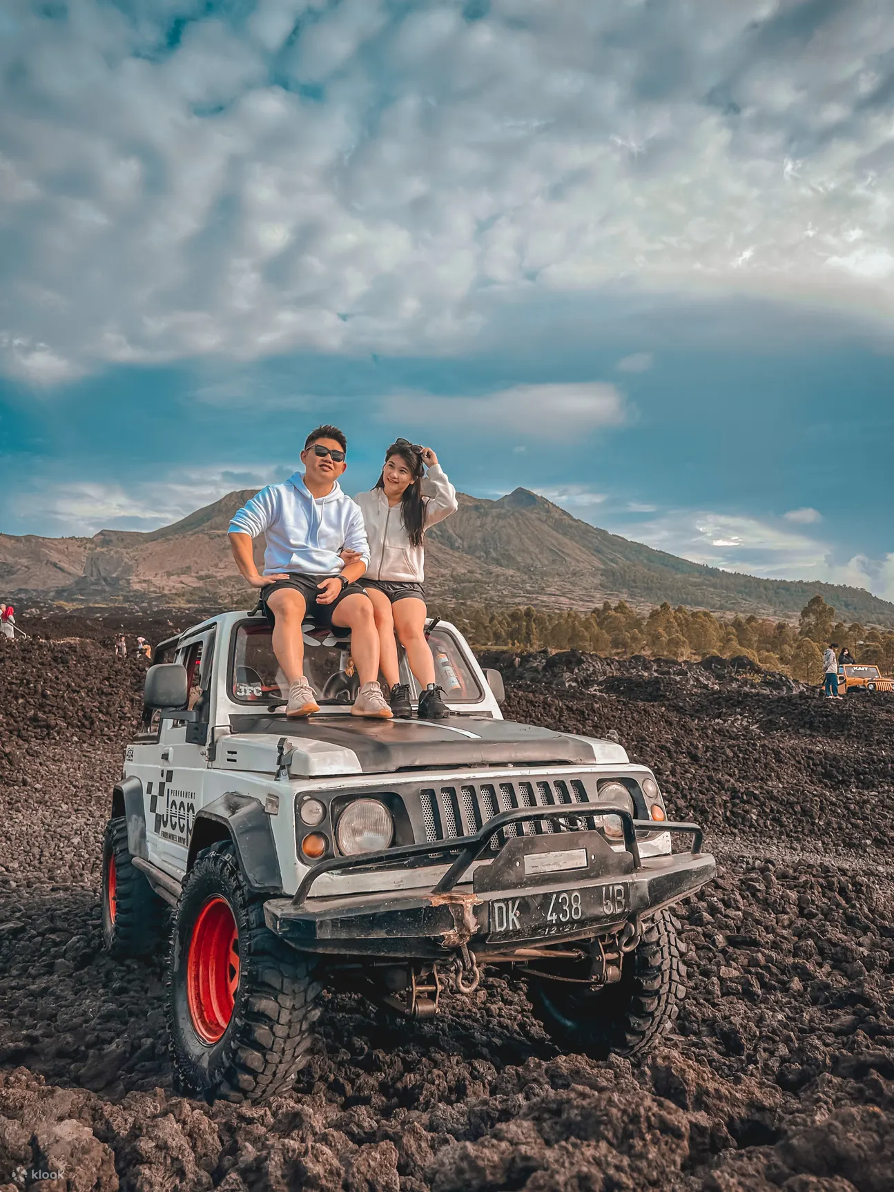 a couple took a photo with a background of Mount Batur