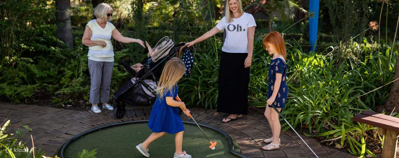 deux femmes et deux jeunes filles jouant au mini-golf dans les jardins botaniques de Wanneroo