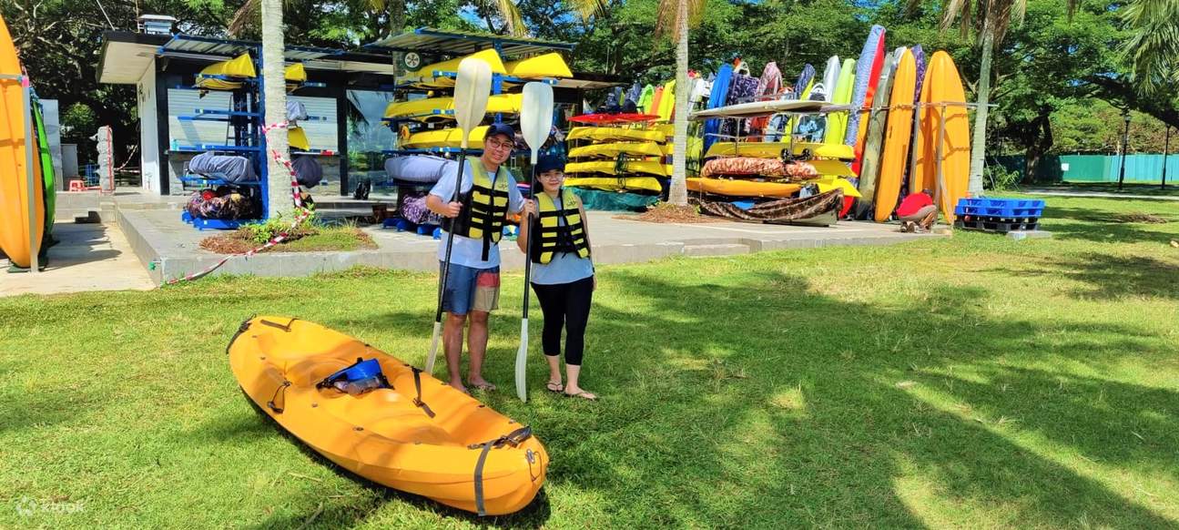 Deux personnes debout avec un kayak