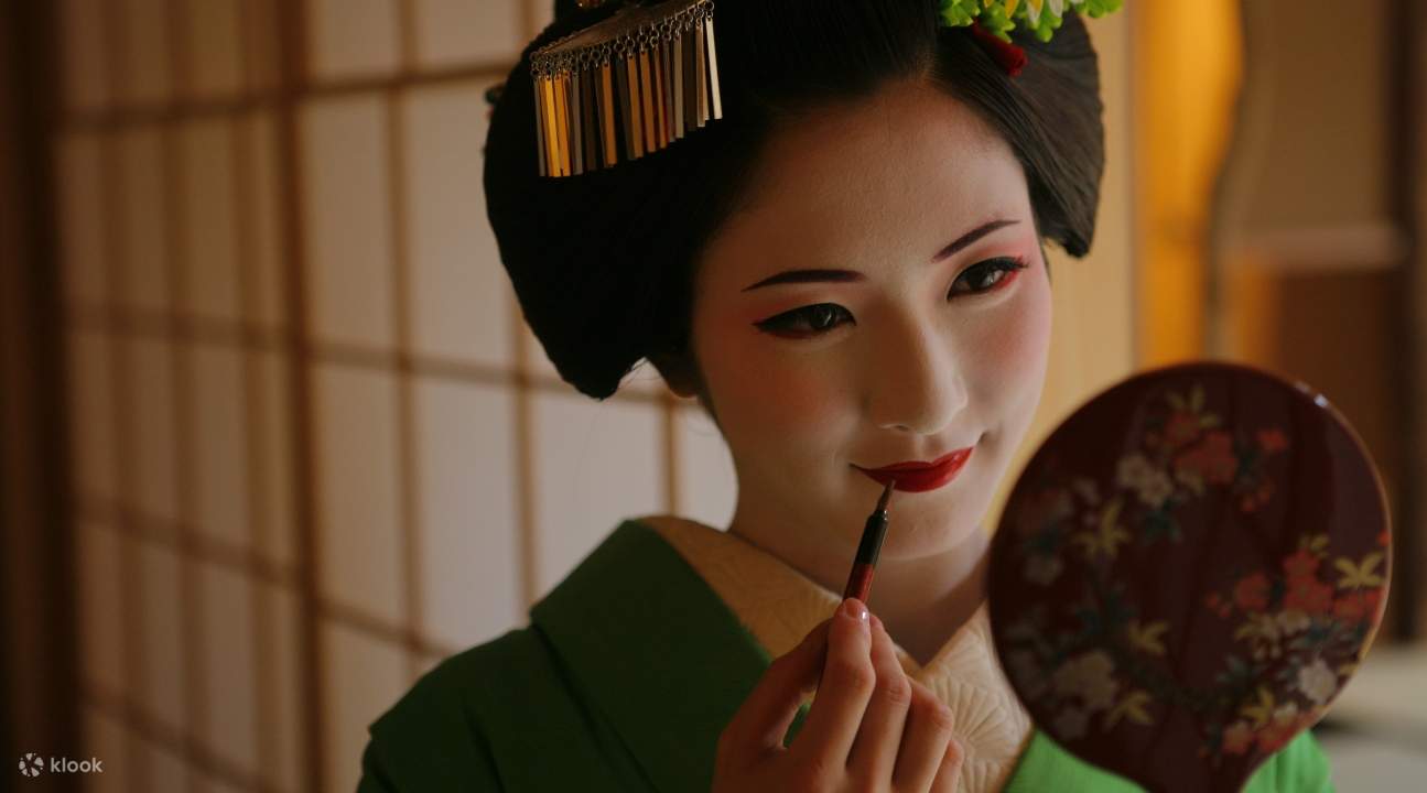 a maiko putting makeup on herself