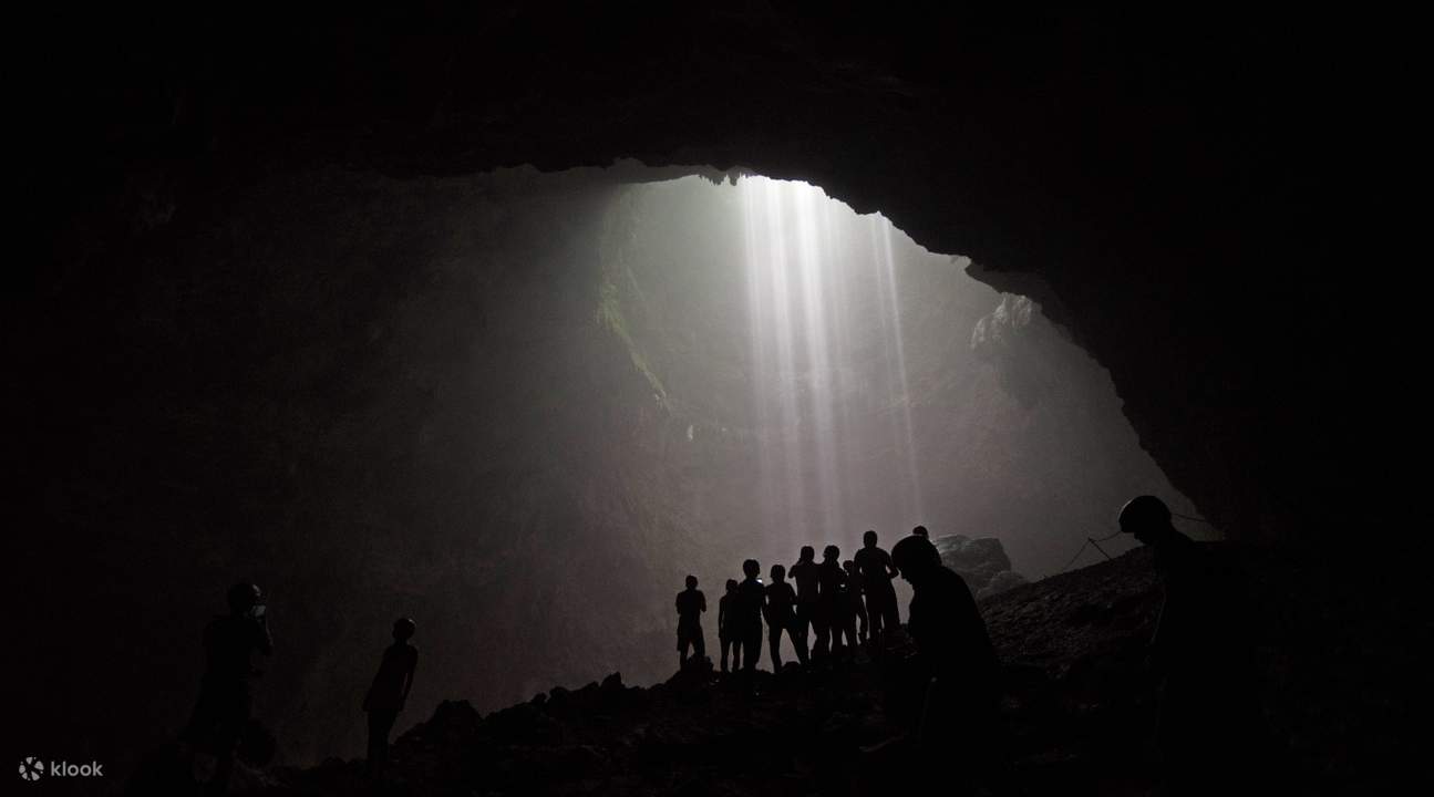 silueta de turistas posando dentro de la cueva de Jomblang