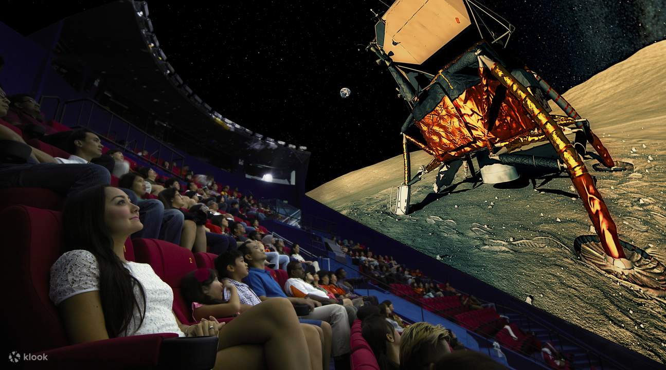 pengunjung menonton film di pusat sains singapura 