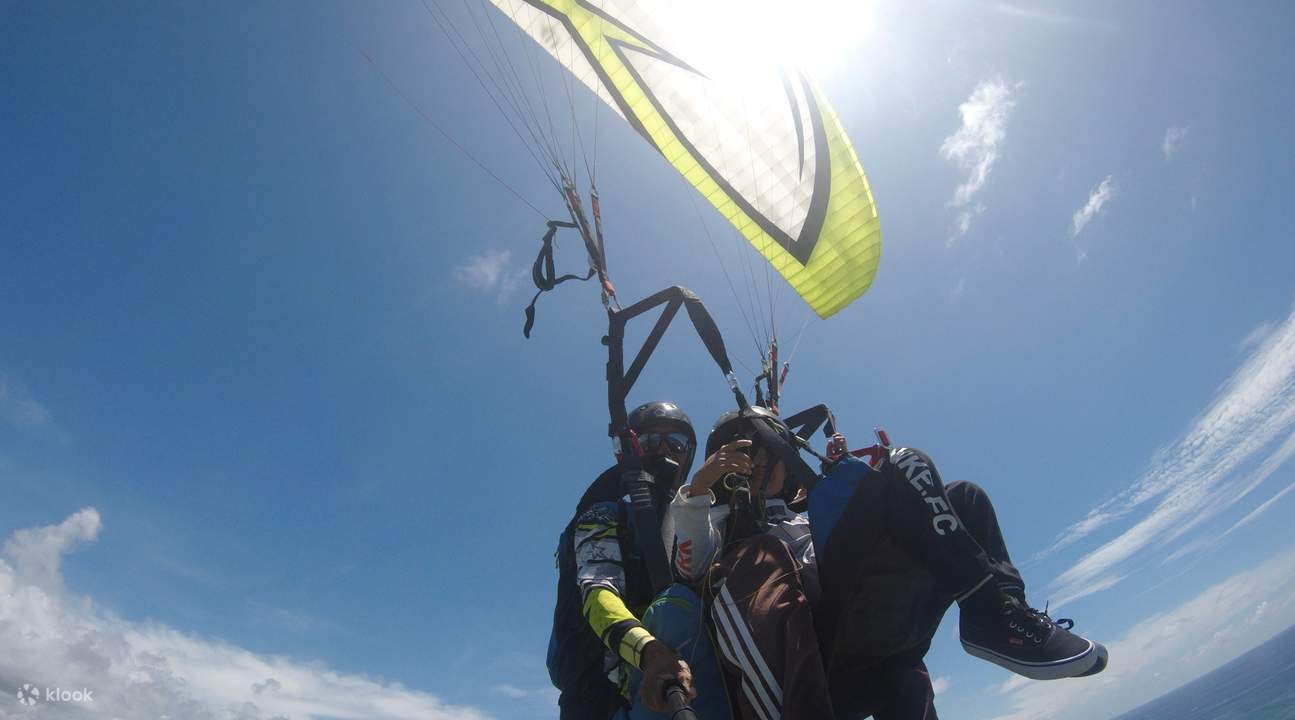varias personas practicando parapente sobre la playa Timbis